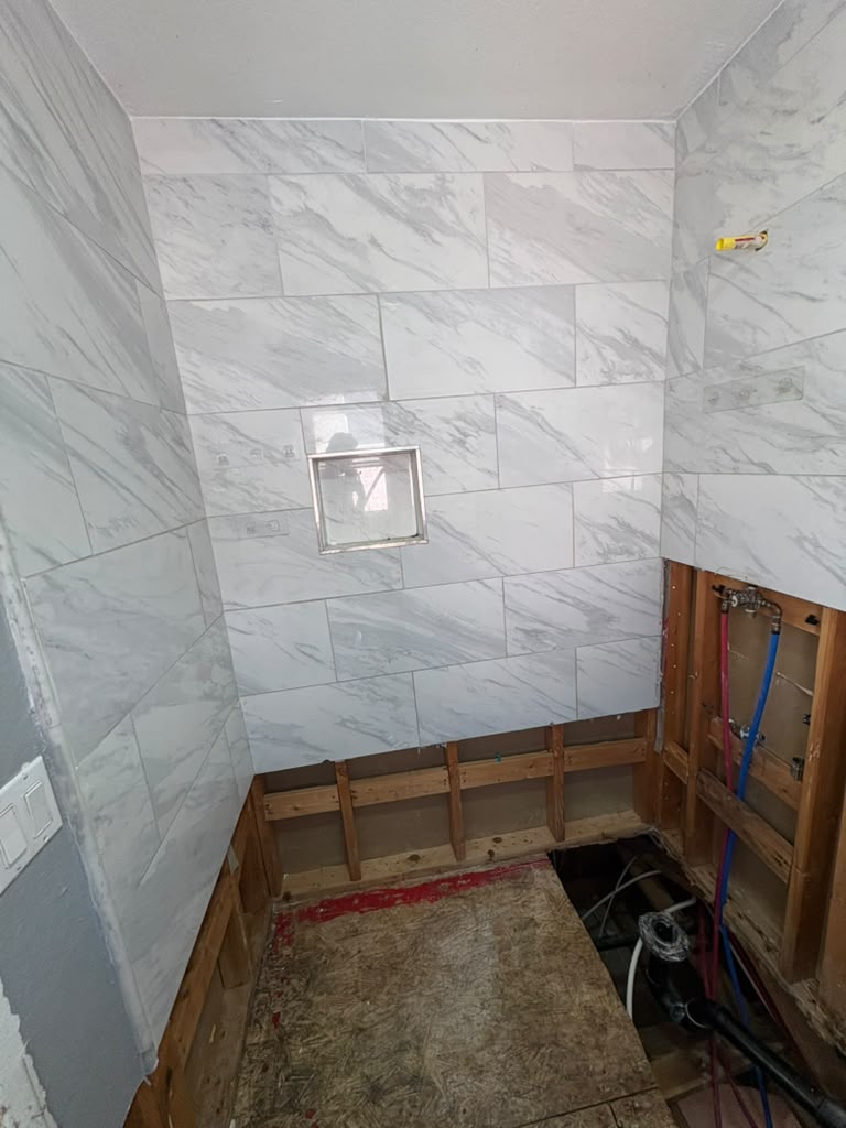 During — shower wall tile going up over exposed framing and rough-in