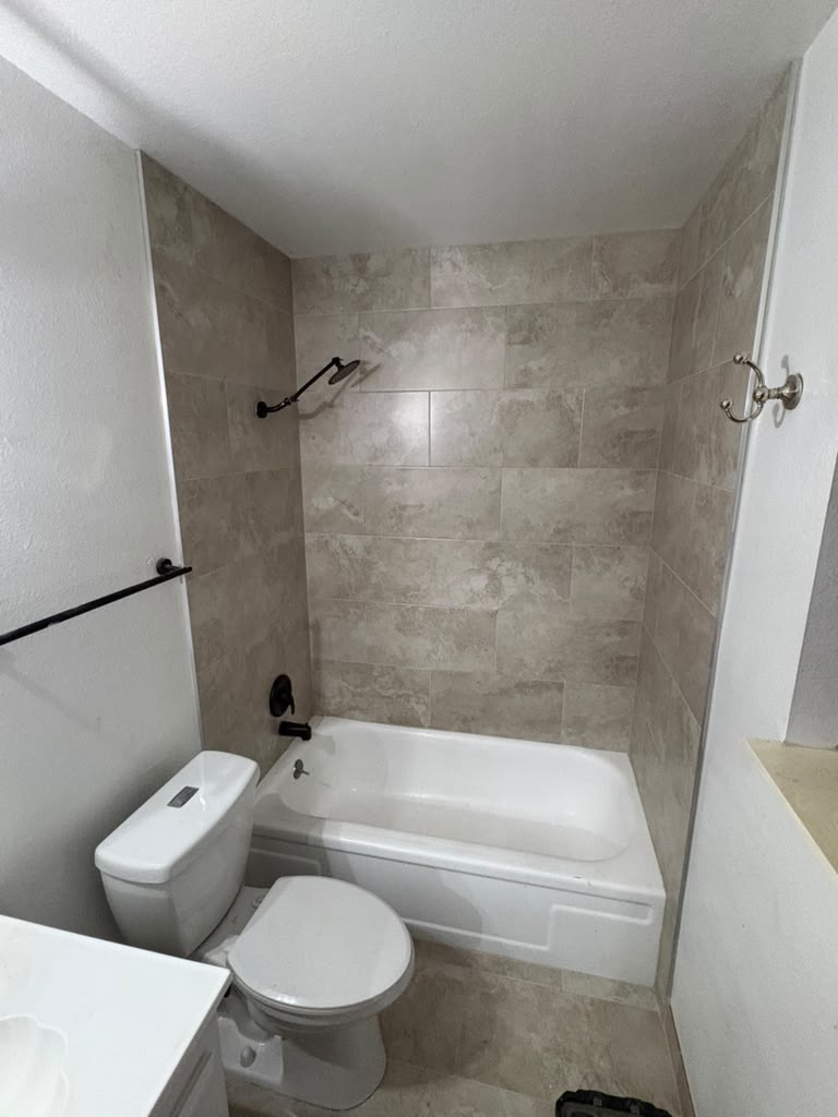 Second bathroom finished — travertine-look tile surround, new tub and matte black fixtures in Las Vegas