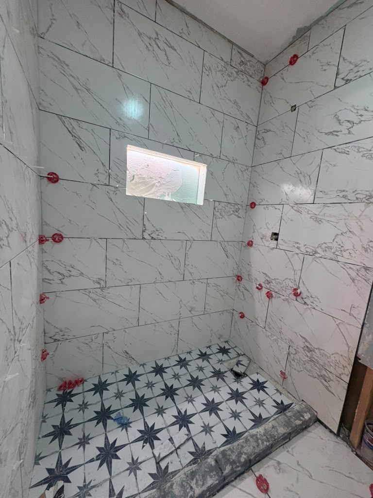 Shower tile set with spacers and star-pattern floor tile in a Las Vegas remodel