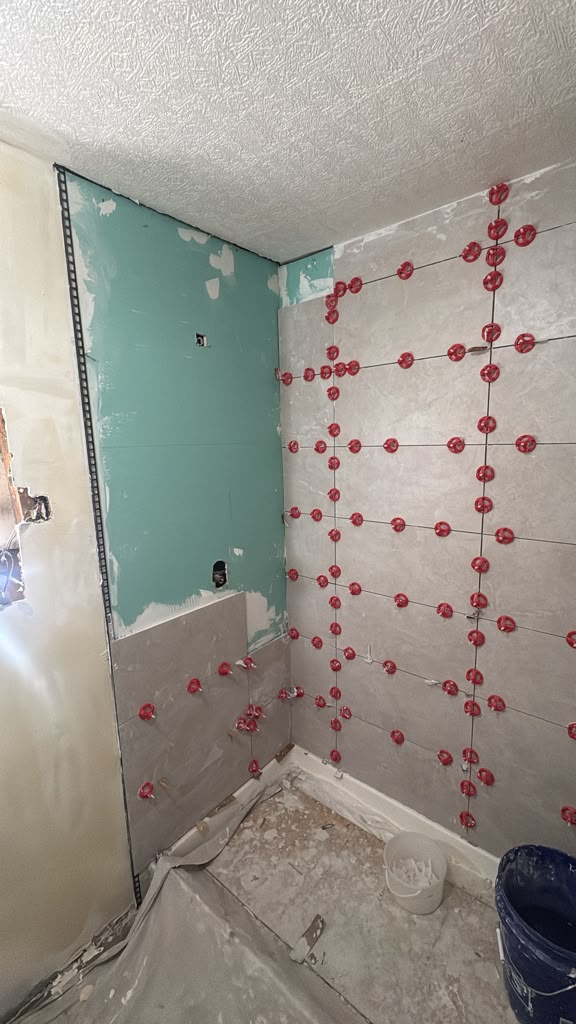 Shower walls with moisture-resistant green board and new grey tile in a Las Vegas bathroom remodel